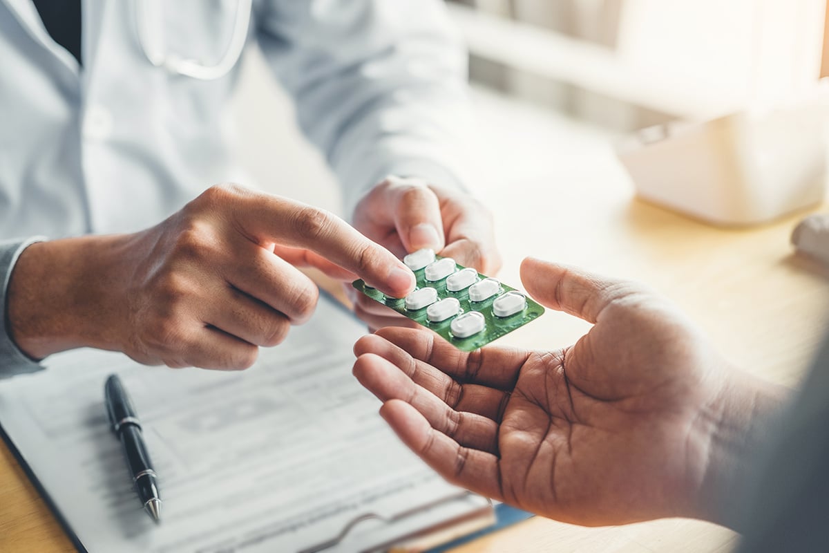 Doctor handing pills to patient