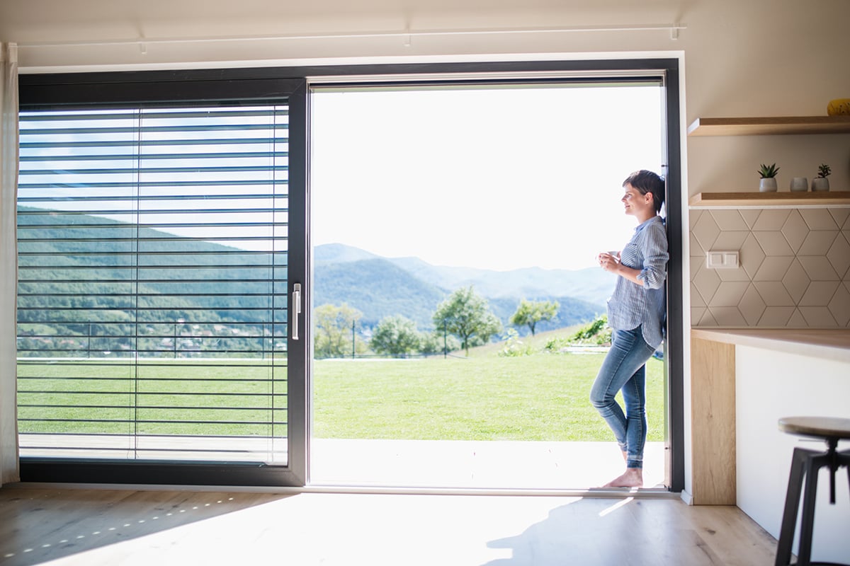 Woman standing at open PVC window